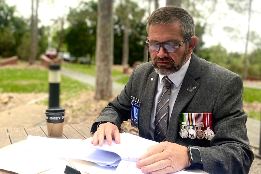 Gulf War veteran Ian Allwood sits in a park reading.